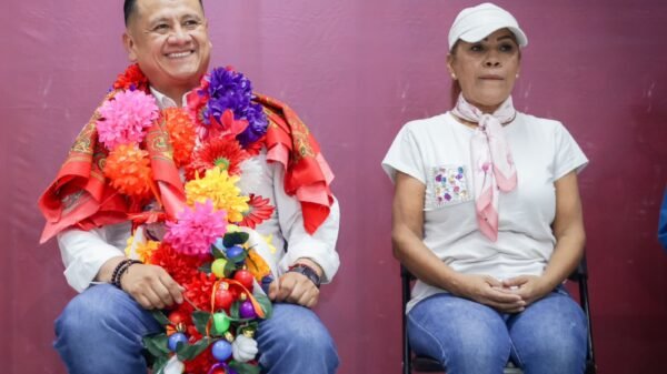 Retrato serio y cercano de Carlos Torres Piña frente a un mapa de Michoacán con íconos que simbolizan conocimiento, cumplimiento y gobernabilidad