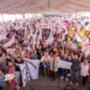Carlos Torres Piña hablando ante una multitud numerosa en un evento al aire libre en Zacapu o Zitácuaro, Michoacán, con banderas y pancartas visibles