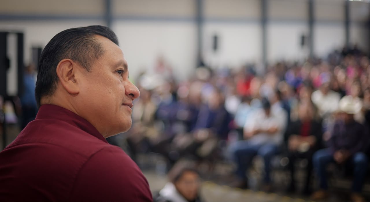 Retrato formal de Carlos Torres Piña frente a símbolos institucionales de la Cámara de Diputados, la Secretaría de Gobierno de Michoacán y la Fiscalía General del Estado