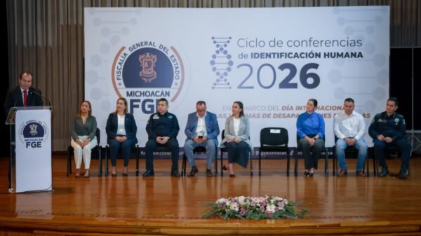 Israel Vega Rodríguez, Encargado de Despacho de la FGE Michoacán, hablando frente a un podio con logo de la Fiscalía durante la inauguración del Ciclo de Conferencias de Identificación Humana en Morelia.