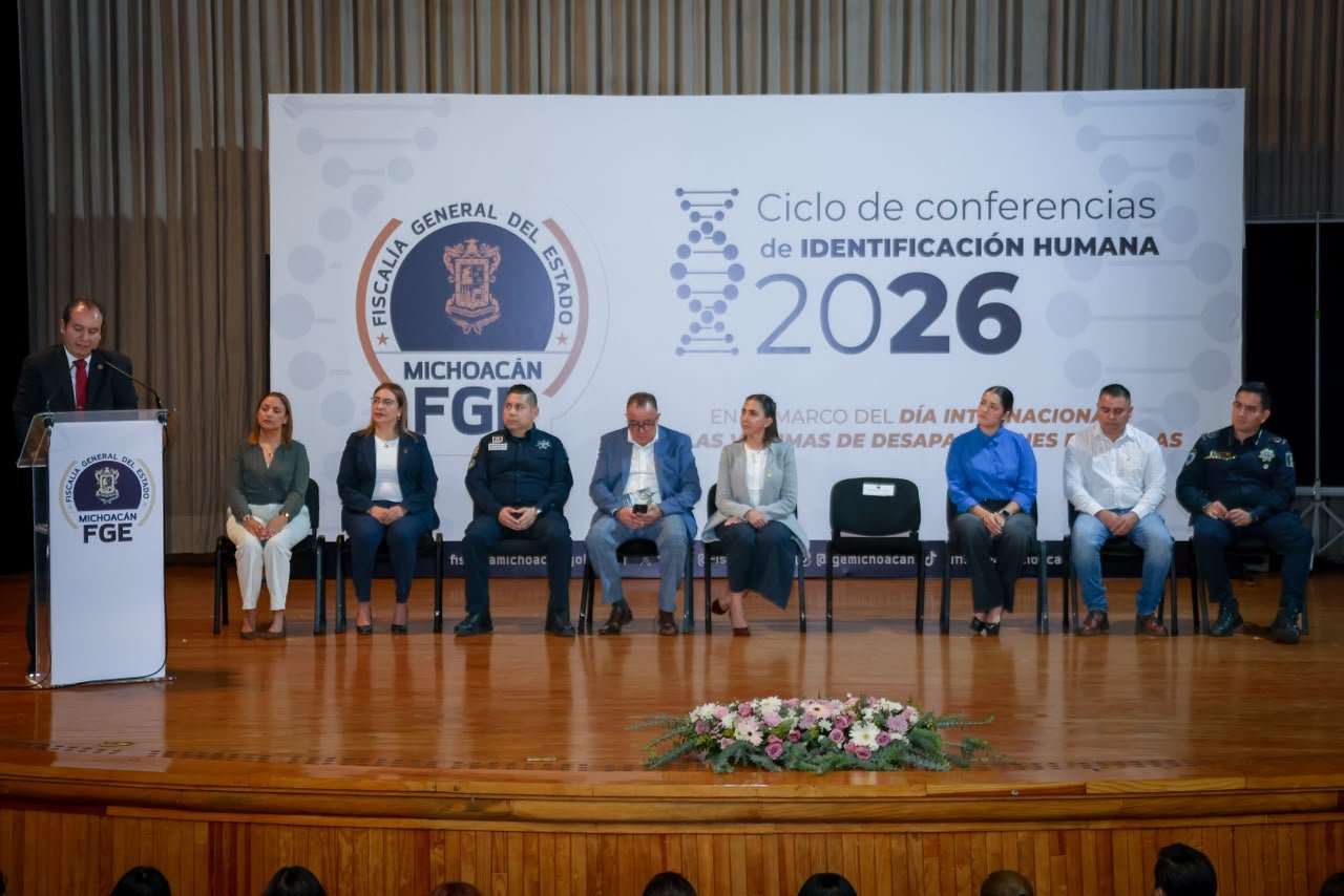 Israel Vega Rodríguez, Encargado de Despacho de la FGE Michoacán, hablando frente a un podio con logo de la Fiscalía durante la inauguración del Ciclo de Conferencias de Identificación Humana en Morelia.