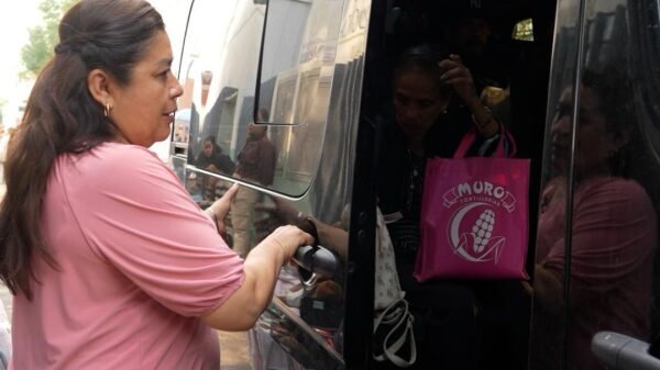 Diputada Belinda Iturbide Díaz junto a un autobús con logotipo de la Casa de Enlace Legislativo en Puruándiro, Michoacán