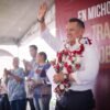 Carlos Torres Piña hablando ante una multitud en la plaza principal de Tiripetío, Michoacán, durante una asamblea informativa.