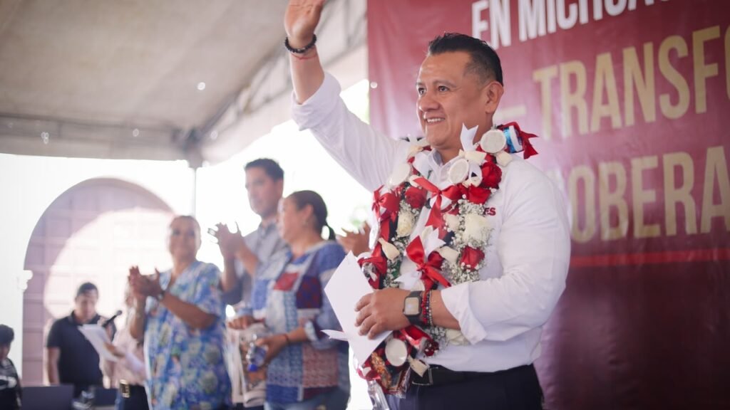 Carlos Torres Piña hablando ante una multitud en la plaza principal de Tiripetío, Michoacán, durante una asamblea informativa.