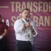 Carlos Torres Piña hablando ante micrófono en un acto público en Morelia, Michoacán, abordando temas de seguridad y registro telefónico