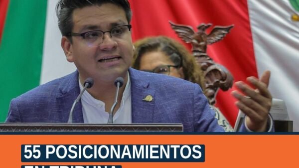 Fotografía del diputado Antonio Carreño Sosa hablando en tribuna del Congreso del Estado en Morelia, con fondo de bandera