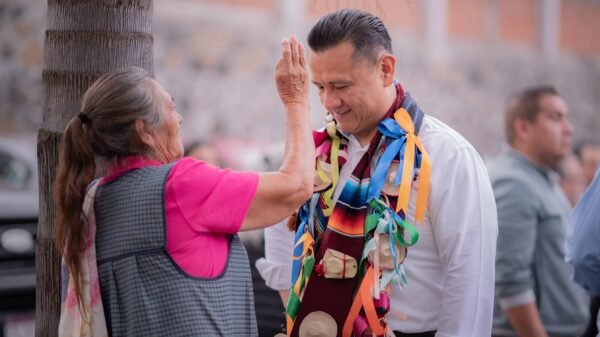Fotografía de Carlos Torres Piña en diálogo directo con ciudadanos en un municipio de Michoacán, en entorno comunitario y cercano