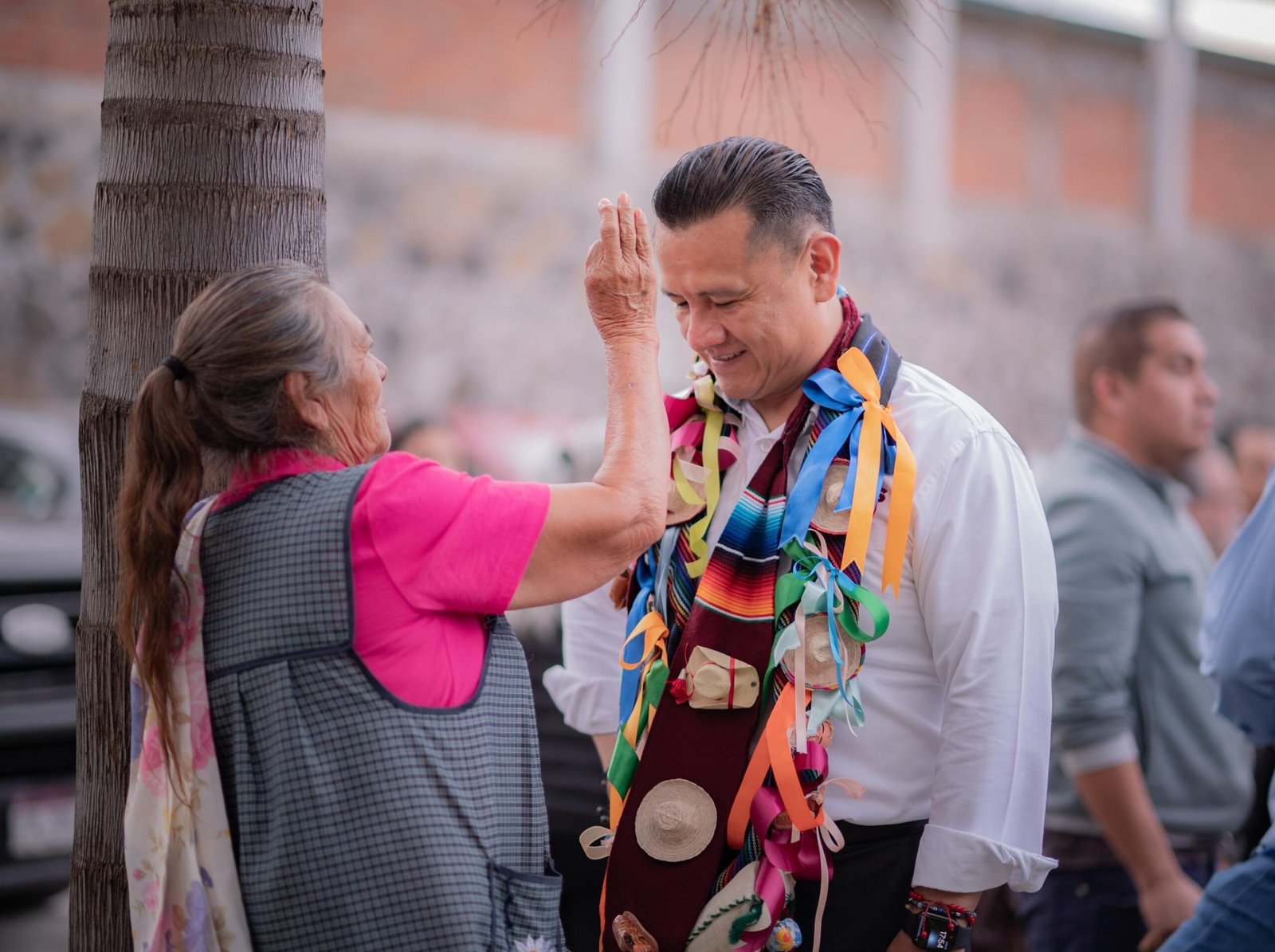Fotografía de Carlos Torres Piña en diálogo directo con ciudadanos en un municipio de Michoacán, en entorno comunitario y cercano