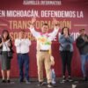 Retrato formal de Carlos Torres Piña frente a un fondo neutro, con símbolos discretos de Michoacán y tres íconos representando educación, justicia y pueblos originarios