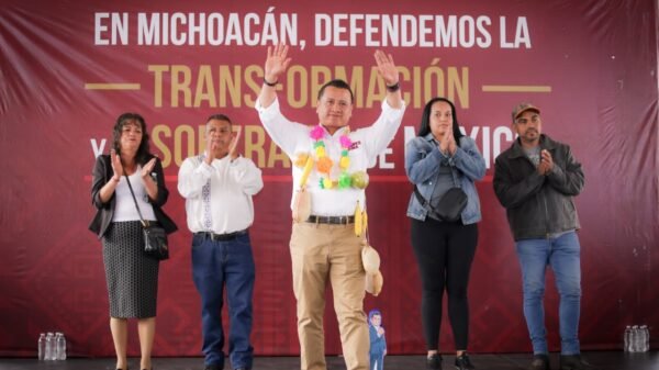 Retrato formal de Carlos Torres Piña frente a un fondo neutro, con símbolos discretos de Michoacán y tres íconos representando educación, justicia y pueblos originarios
