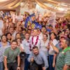 Carlos Torres Piña hablando ante micrófono en evento público en Morelia, Michoacán, con logo de 'Plan Michoacán por la Paz y la Justicia' visible en fondo
