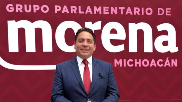 Fotografía de Iván Arévalo Vera hablando ante micrófono en evento del Segundo Informe Legislativo en el Congreso de Michoacán, con bandera estatal visible