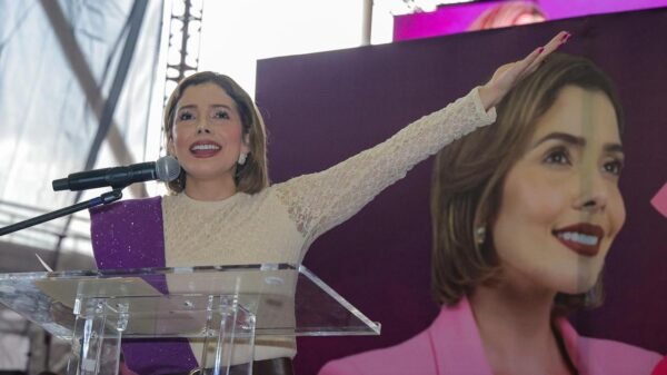 Brissa Arroyo segundo informe: diputada hablando frente a multitud en Morelia, Michoacán, con bandera de Michoacán y logo
