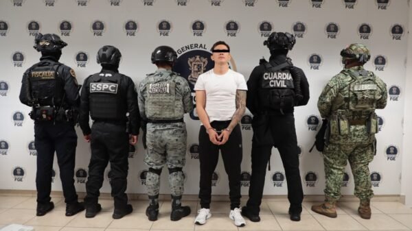 Fiscalía de michoacán detención: imagen simbólica de sello oficial de la FGE sobre fondo azul con silueta de policía y mapa