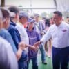 Carlos Torres Piña caminando por una comunidad rural de Michoacán, conversando con habitantes locales, como parte de su
