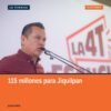 Carlos Torres Piña hablando en un evento público en Jiquilpan, Michoacán, con micrófono y fondo de bandera mexicana