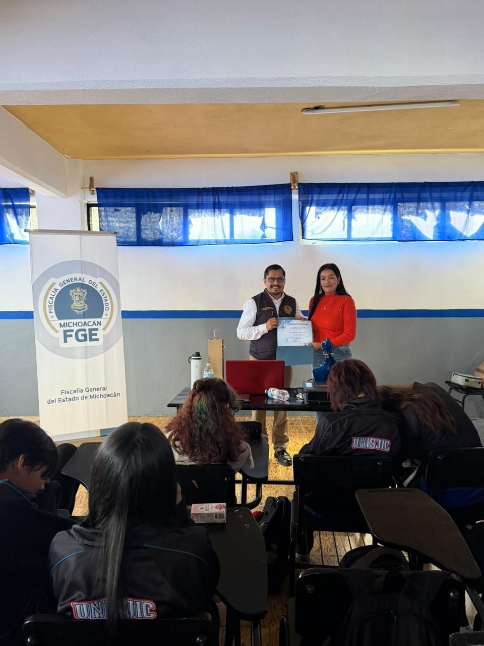 Grupo de estudiantes en aula universitaria en Morelia durante charla sobre prevención del acoso escolar impartida por la FGE