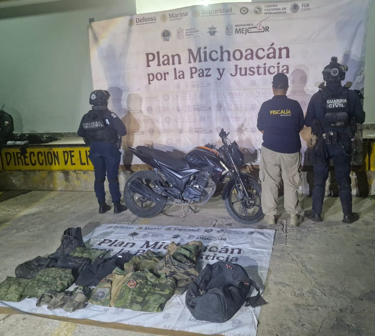 Motocicleta Italika Z200 negra con naranja sin placas y mochila con uniformes tácticos en Apatzingán