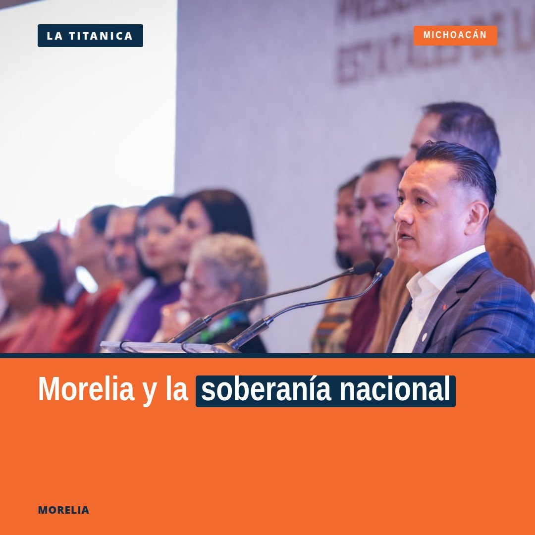 Carlos Torres Piña hablando en un acto público en Morelia, Michoacán, con bandera mexicana al fondo, durante el 205